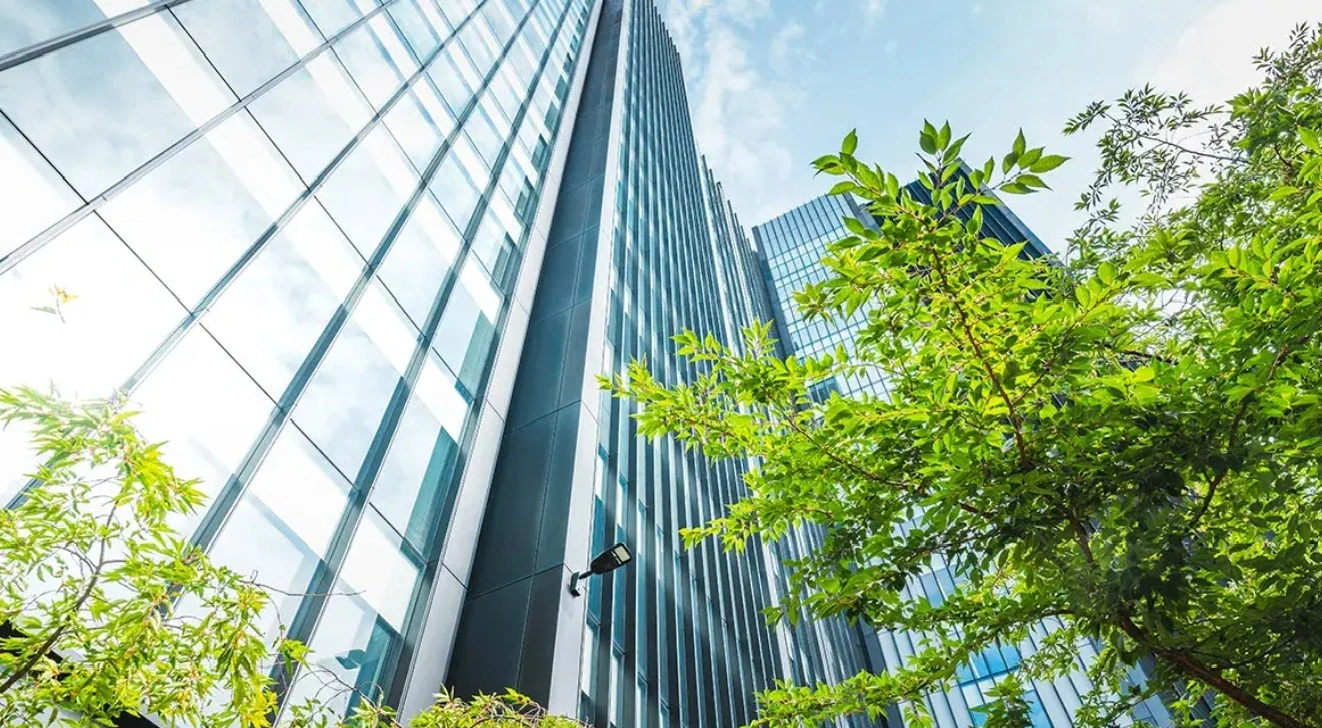 Architecture contemporaine vitrée avec arbres et ciel bleu